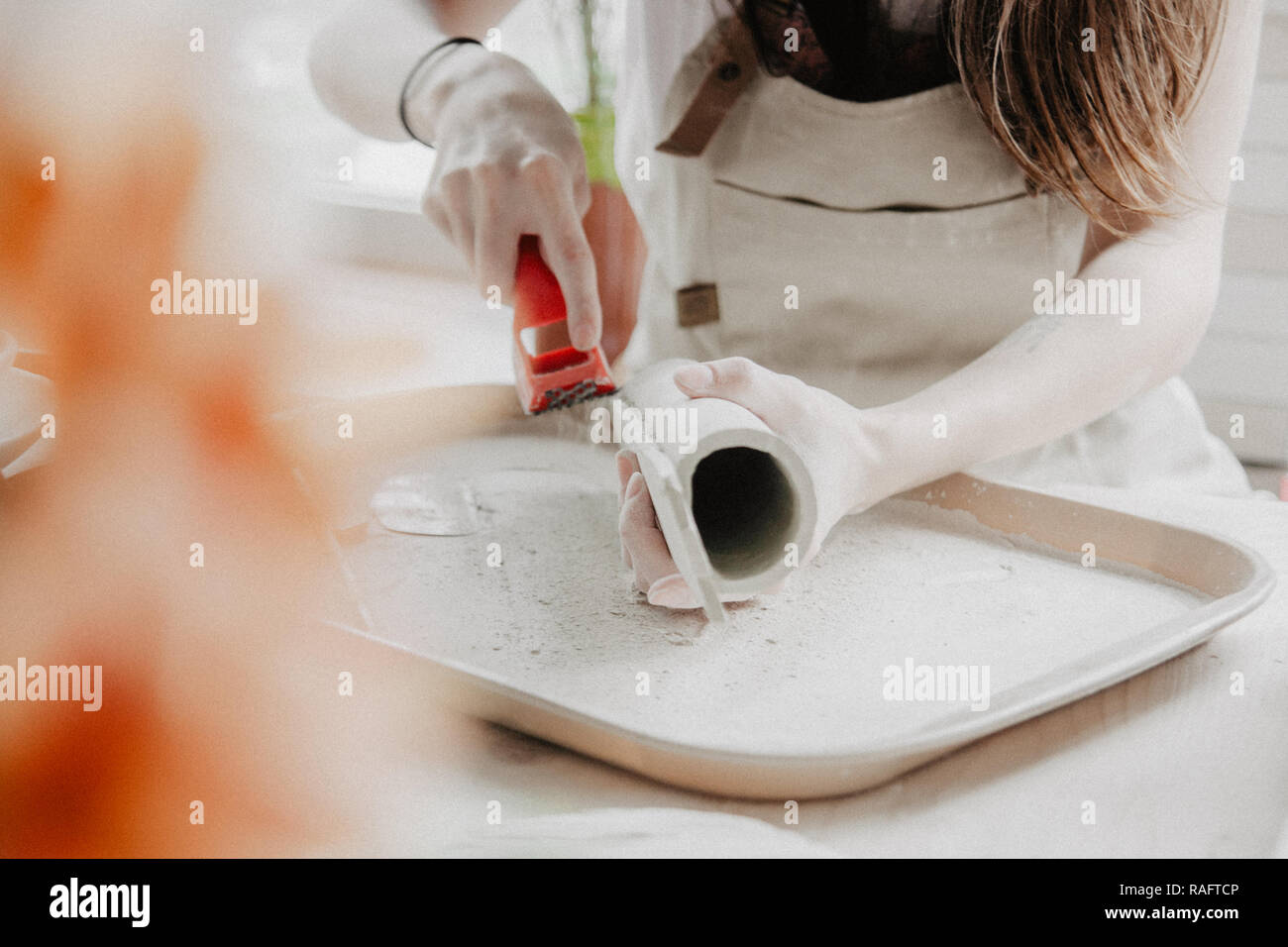 Donna fare ceramica. Vista dettagliata del processo di levigatura a piastra di argilla Foto Stock