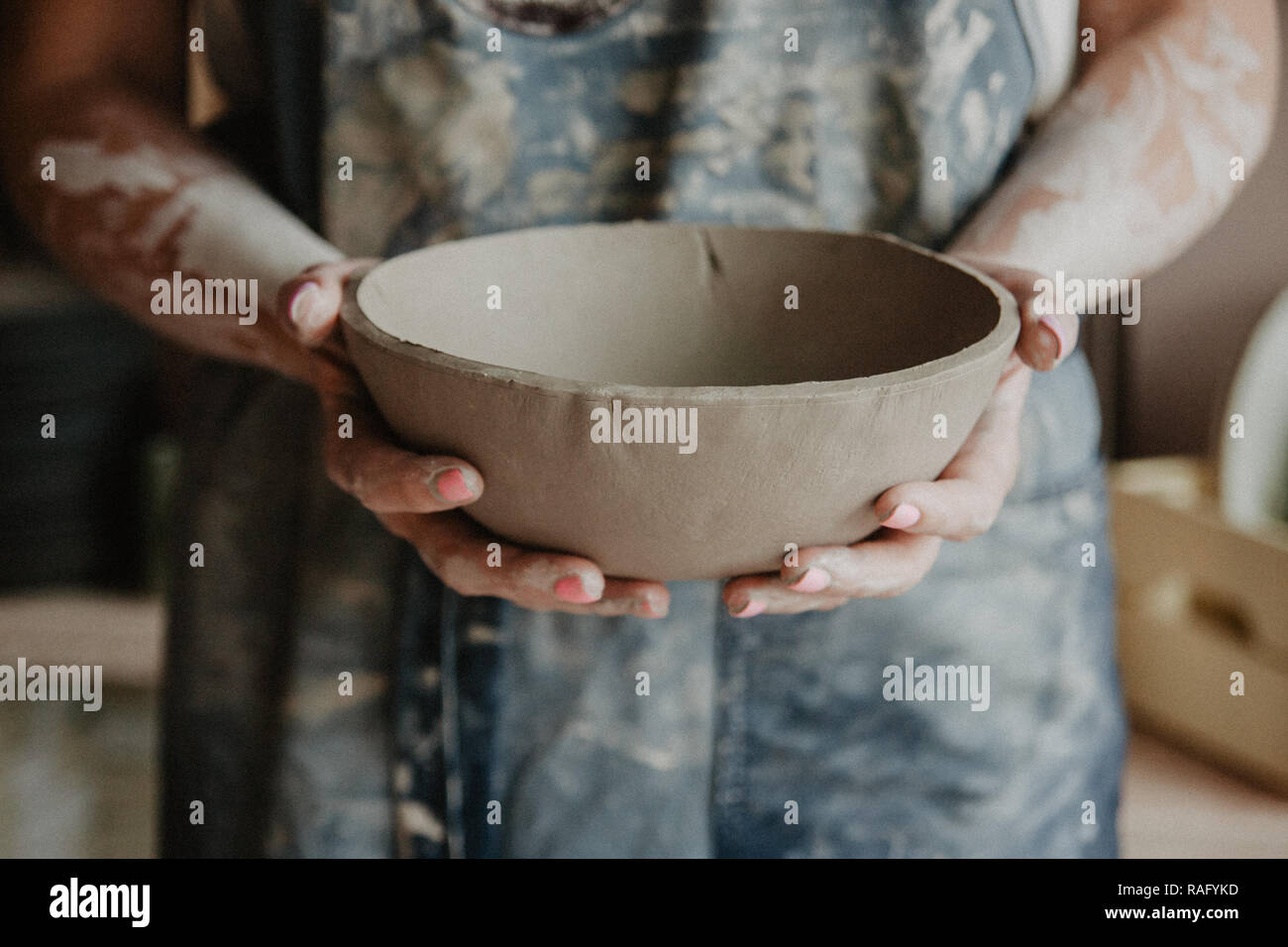 Ceramiche, argilla, arte ceramica concetto closeup sulle mani del giovane maestro con la piastra grande da terra refrattaria Foto Stock