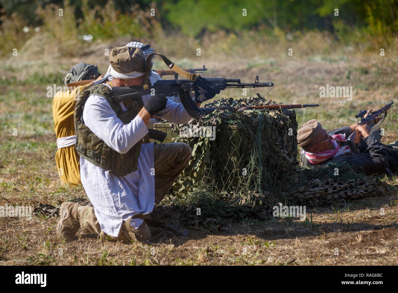 Festival storici Sambek altezze. Mujahideen sparare da dietro il coperchio Foto Stock