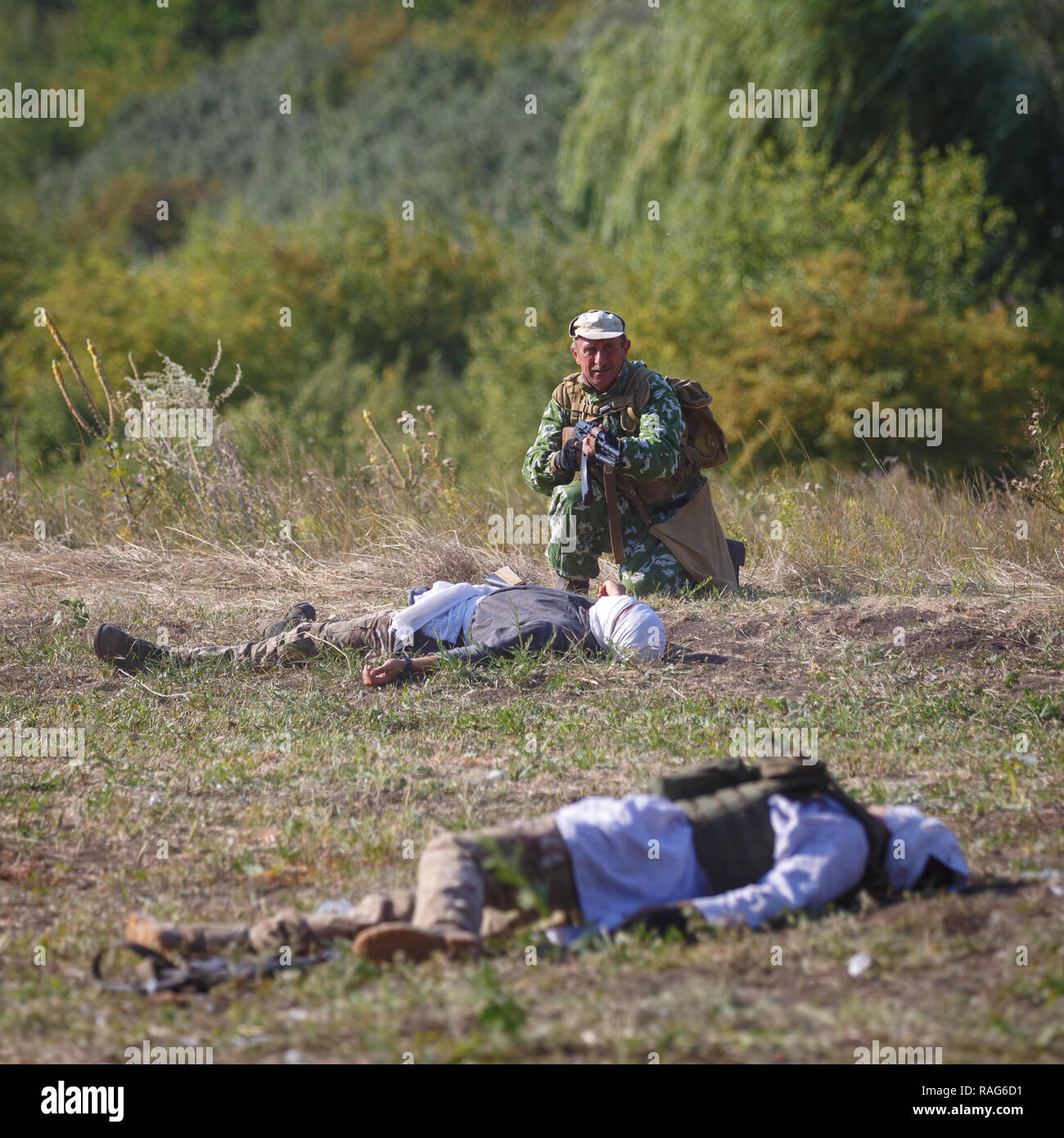 Festival storici Sambek altezze. Soldato sovietico con una pistola in mano contro lo sfondo dell'assassinato Mujahideen Foto Stock