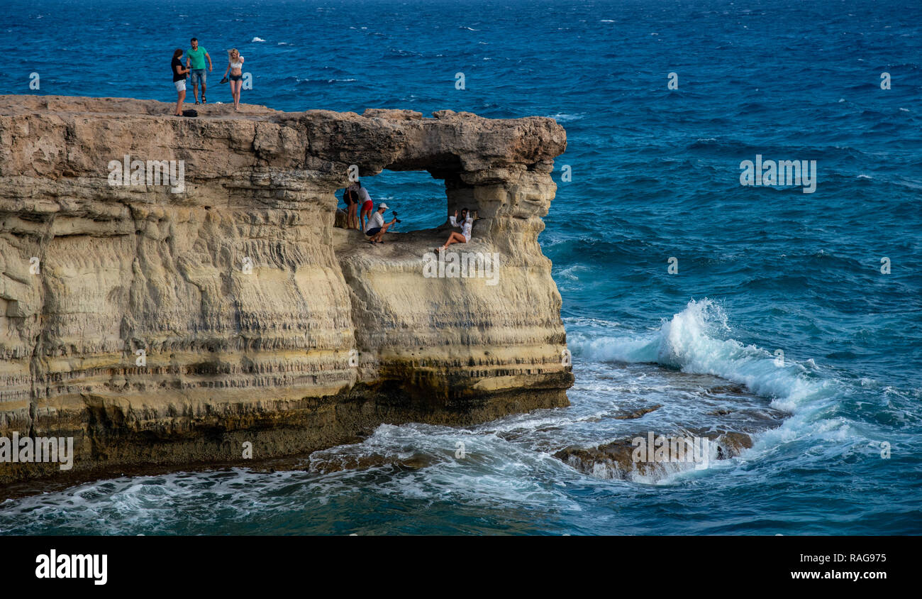 Protaras, Cipro - 30 Luglio 2018: persone in piedi e seduti sulle rocce, godendo le chiare acque cristalline al famoso Capo Greco a Protaras area in Foto Stock