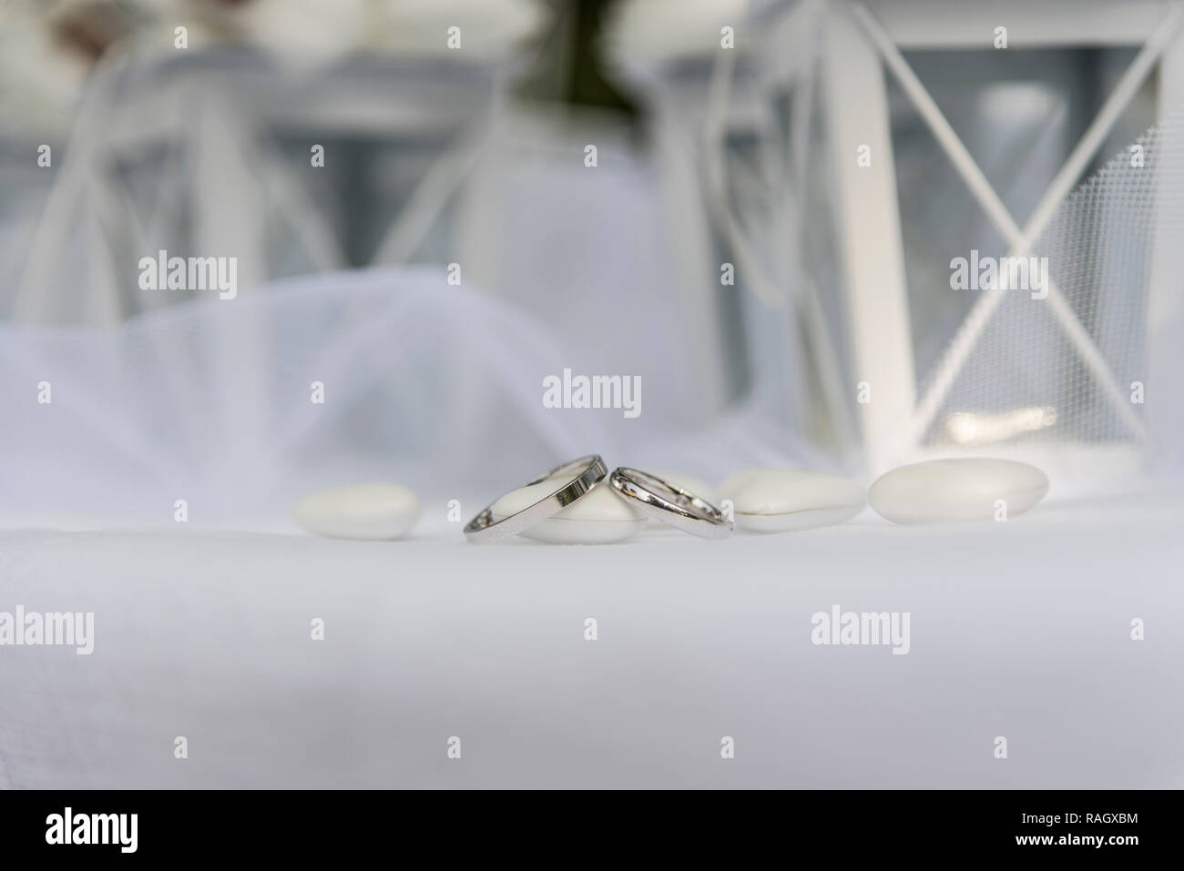 Close up di anelli di nozze nei pressi di confetti e bomboniera Foto Stock