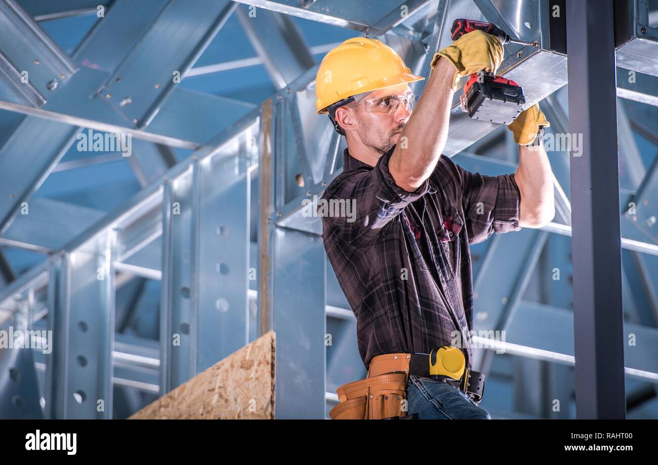 Lavoratore sulla costruzione dello scheletro del telaio in acciaio di fissaggio elementi di metallo. Industria edile. Foto Stock