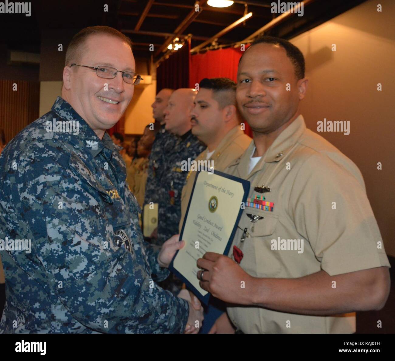 SILVERDALE, nello Stato di Washington (Feb. 8, 2017) - Capt. Alan Schrader (sinistra), la Base Navale di Kitsap (NBK) comandante, presenta uno specialista della logistica 1a classe Nicholas Coleman con la buona condotta medaglia durante una chiamata mani tenutasi presso l'NBK-Bangor Teatro. Più di trenta premi e decorazioni sono stati elargiti per NBK personale durante l'evento. Foto Stock