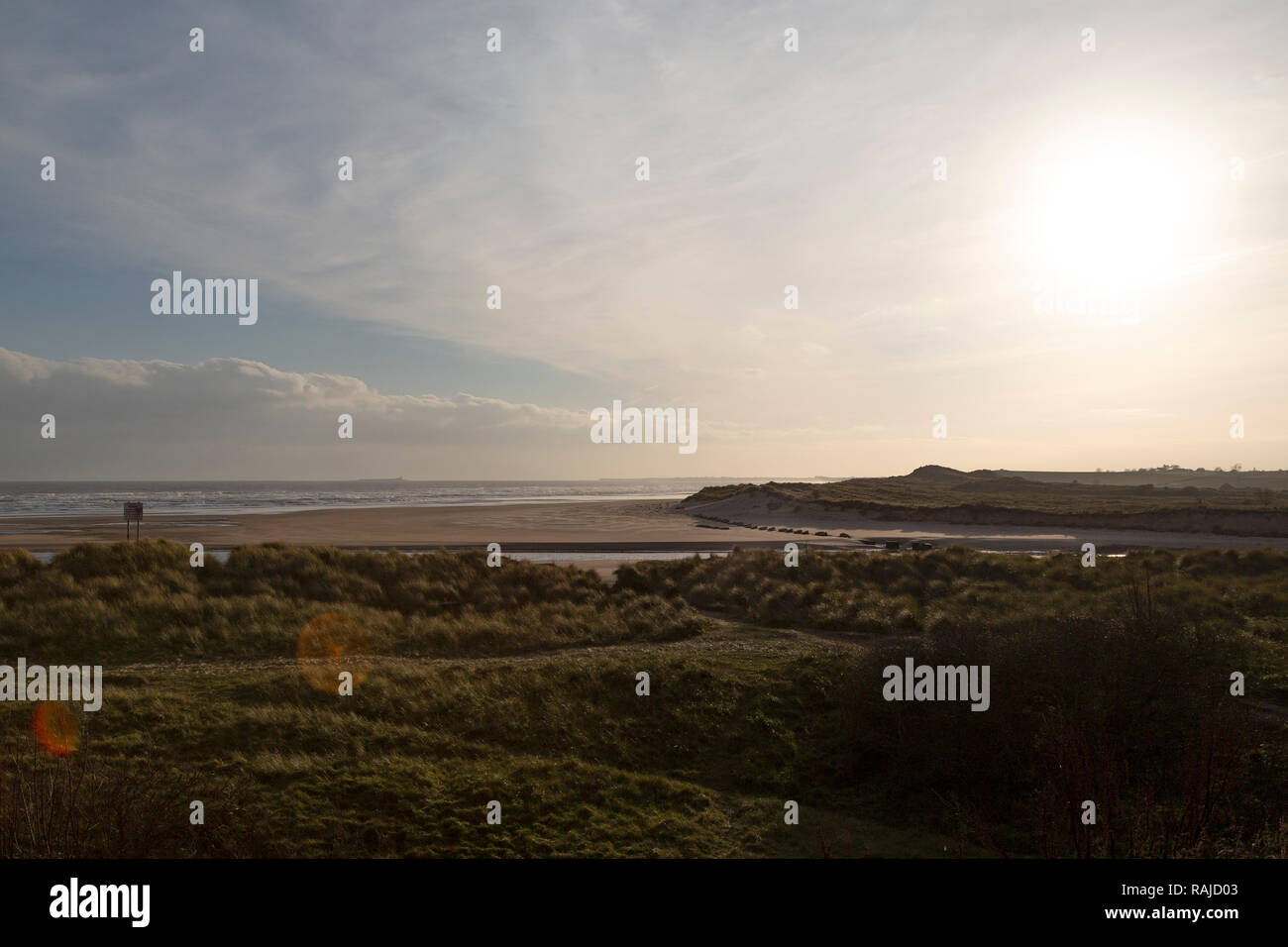 Un esempio di lens flare. Esso si verifica durante un inverno di sparare con bassa sun sulle dune a Alnmouth in Northumberland, Inghilterra. Foto Stock