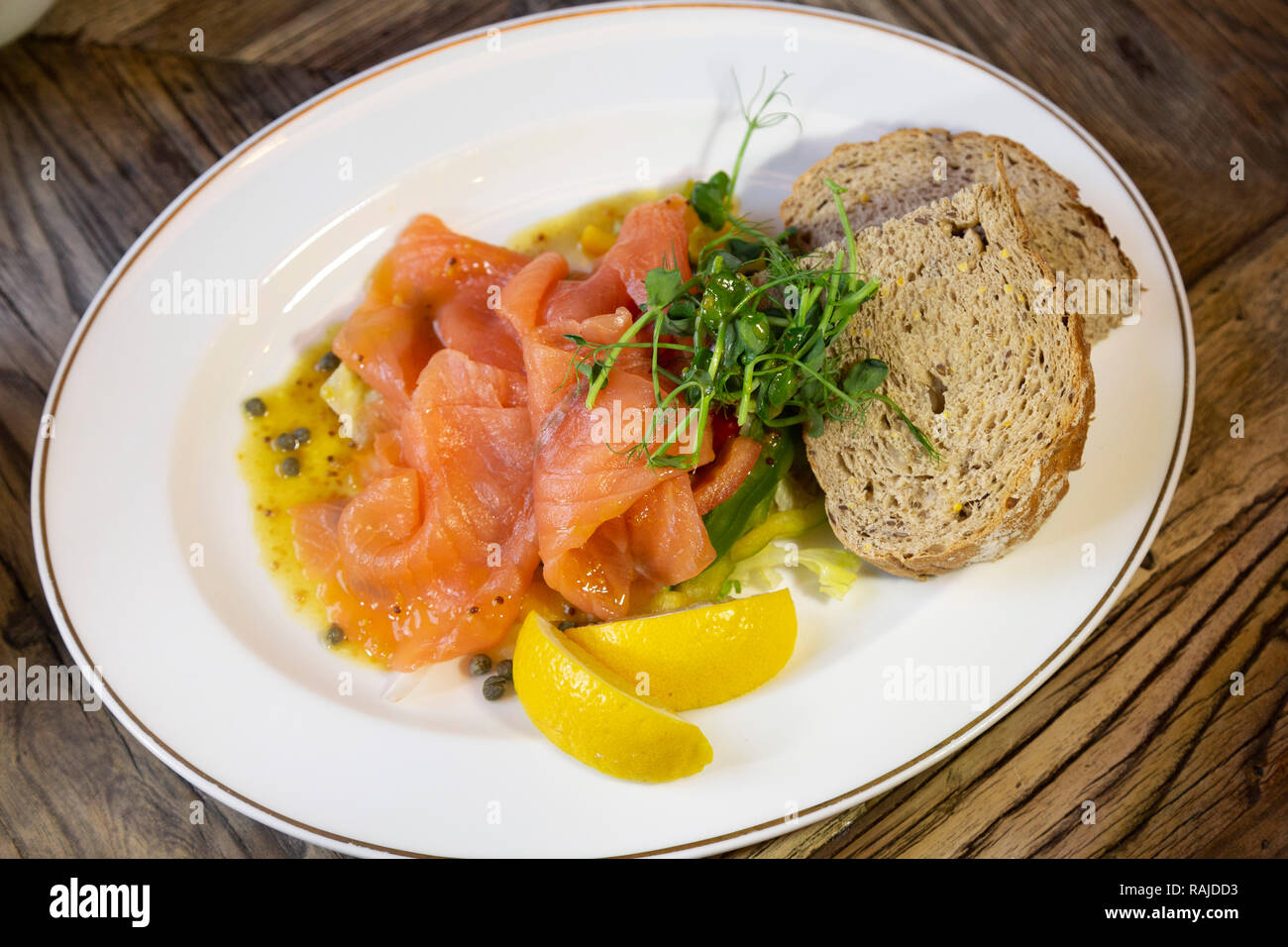 Salmone affumicato servita con pane integrale e spicchi di limone. Il salmone è scozzese. Foto Stock