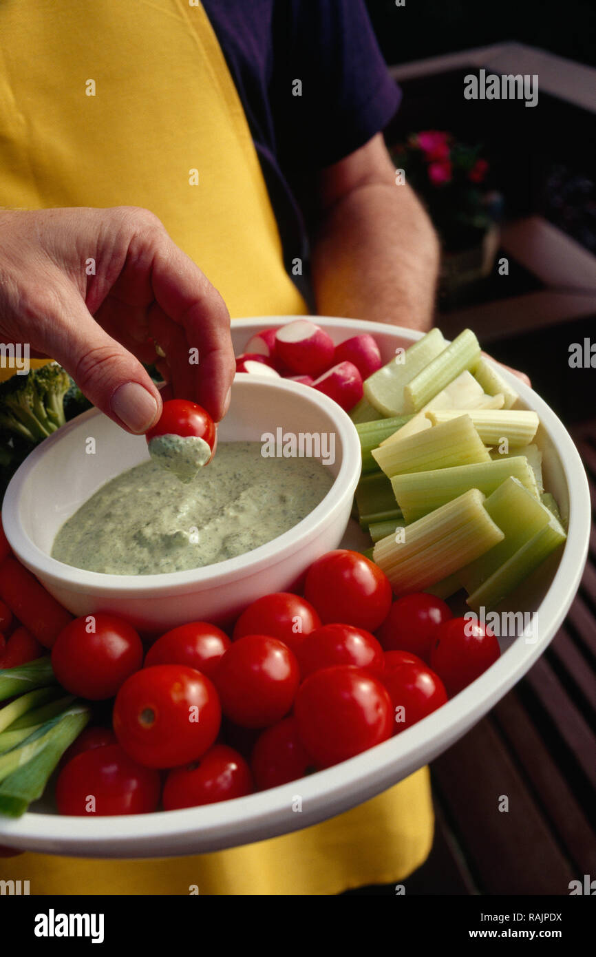 Host passando un piatto di verdure e Dip, STATI UNITI D'AMERICA Foto Stock