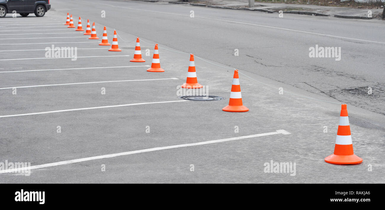 Parcheggio auto e arancio cono di traffico. Chiuso parcheggio auto con contrassegno bianco e cono del traffico su strada utilizzata segno di avvertimento sulla strada Foto Stock