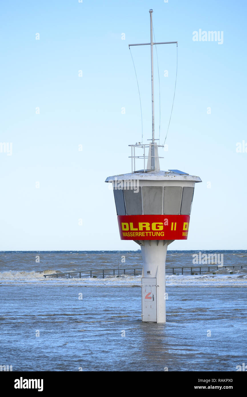 Bay watch tower in spiaggia allagata con acqua alta contro un cielo blu in Travemuende, Mar Baltico, l'etichetta DLRG - Wasserrettung significa vita tedesca Sav Foto Stock