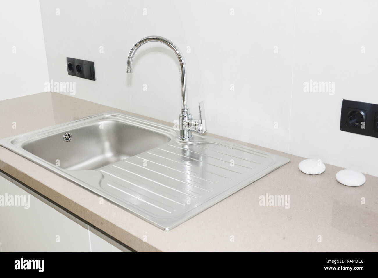 Metallo lavello da cucina. Cucina moderna con rubinetto in metallo e metallo lavello da cucina. Foto Stock