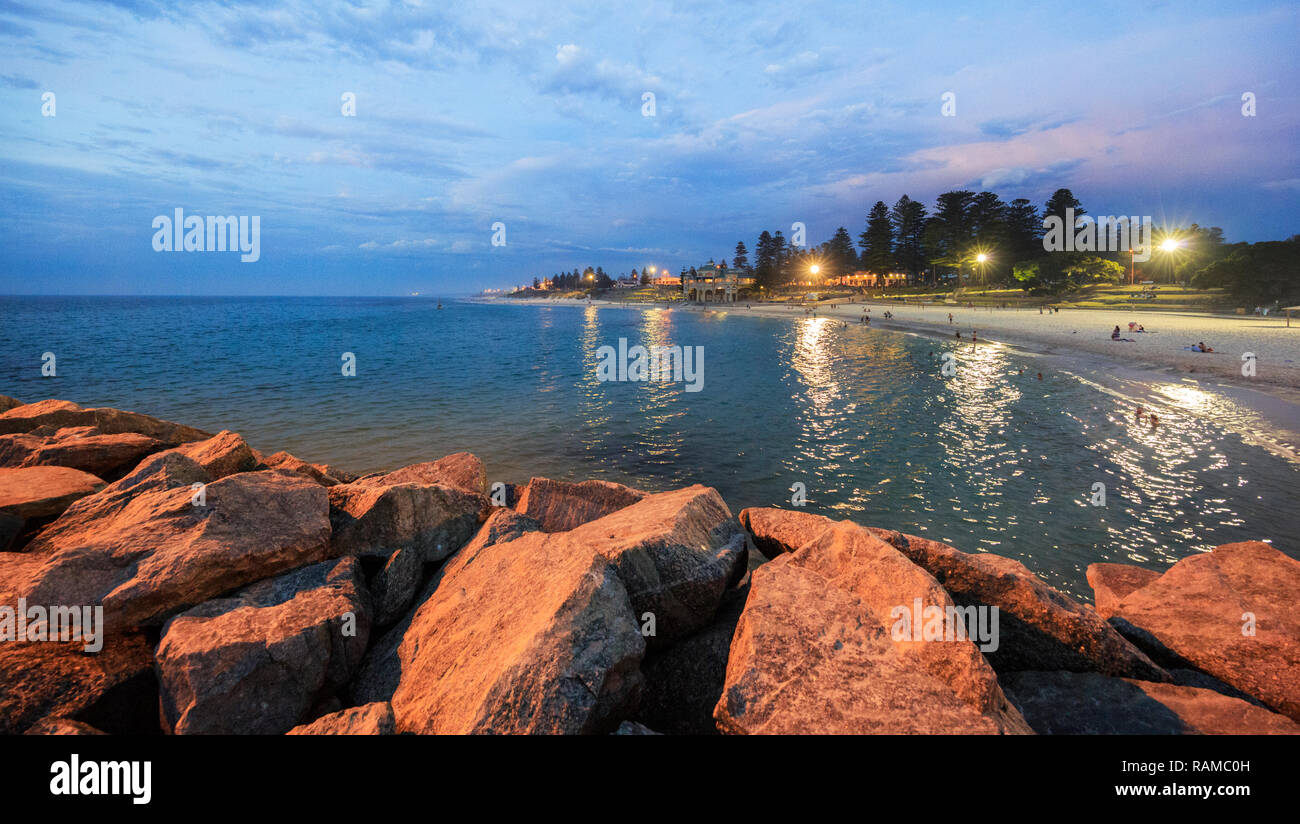 La spiaggia e l'oceano illuminata da proiettori su una mite serata d'estate. Foto Stock