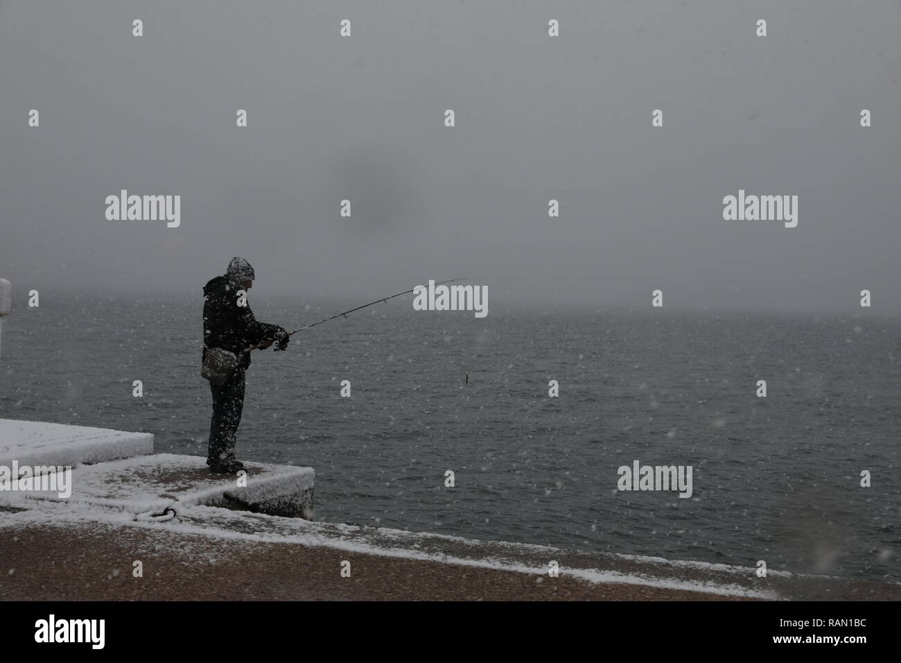 Salonicco, Grecia. 4 gennaio, 2019. Un uomo è visto la pesca nella neve in Salonicco, Grecia, gen. 4, 2019. Molte parti del paese sono stati colpiti da un freddo estremo a scatto e la nevicata di recente a causa di una bassa pressione di sistema meteo denominato 'Sophia'. Nella città settentrionale di Salonicco, due voli internazionali sono stati annullati e cinque sono state deviate verso altri aeroporti greci giovedì, le autorità locali hanno annunciato. Credito: Lefteris Partsalis/Xinhua/Alamy Live News Foto Stock