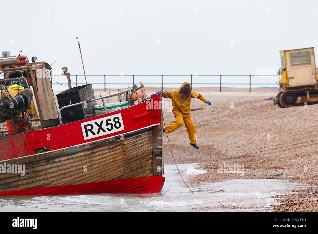 Hastings, East Sussex, Regno Unito. 05 gen, 2019. Regno Unito: Meteo un pescatore salti dalla sua barca da pesca dopo lo sbarco a riva sul stade, la spiaggia più grande lanciato della flotta di pesca nel Regno Unito, Hastings, East Sussex. © Paul Lawrenson 2018, Photo credit: Paolo Lawrenson / Alamy Live News Foto Stock