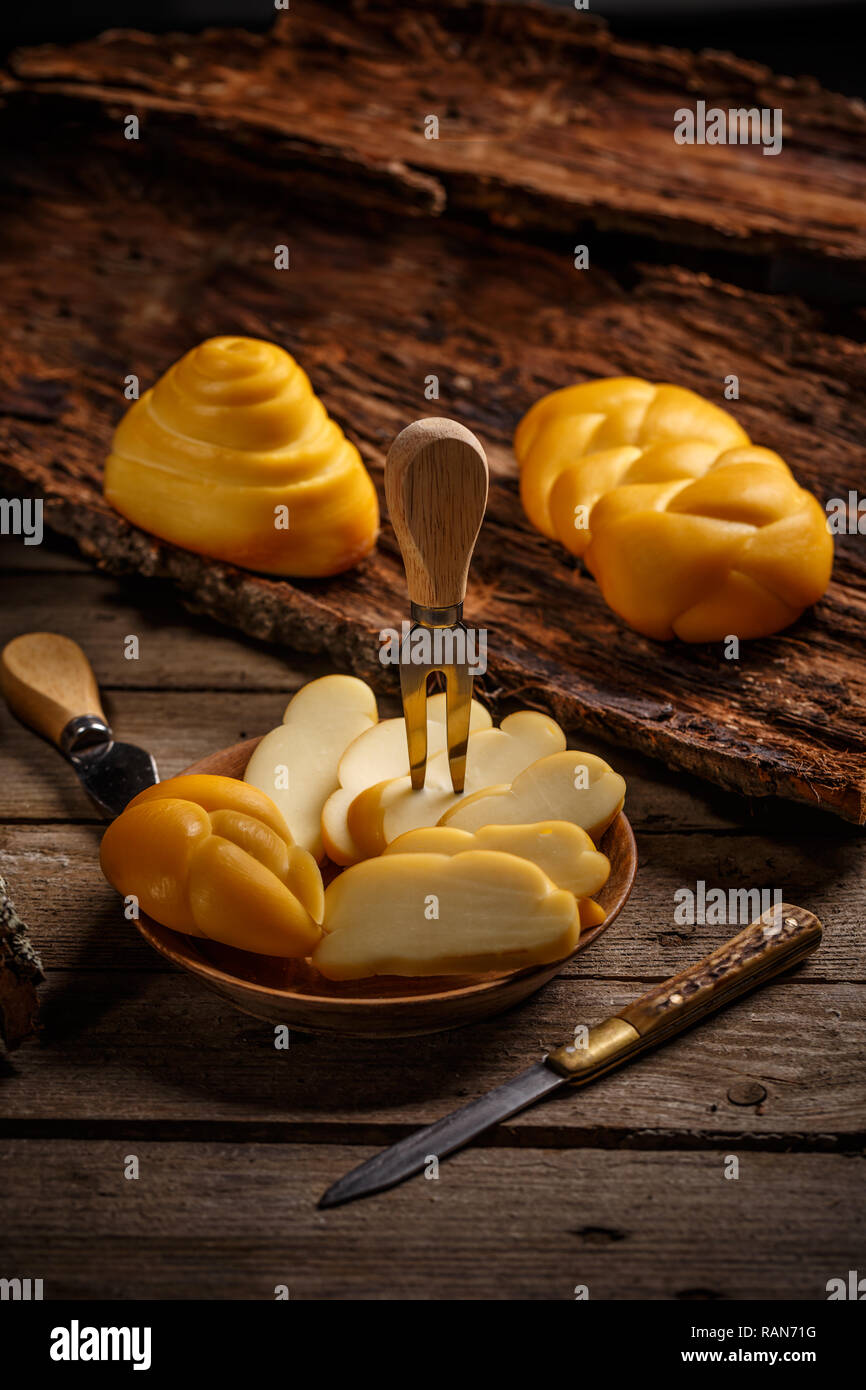 Treccia affumicata formaggio servita sul piatto di legno Foto Stock