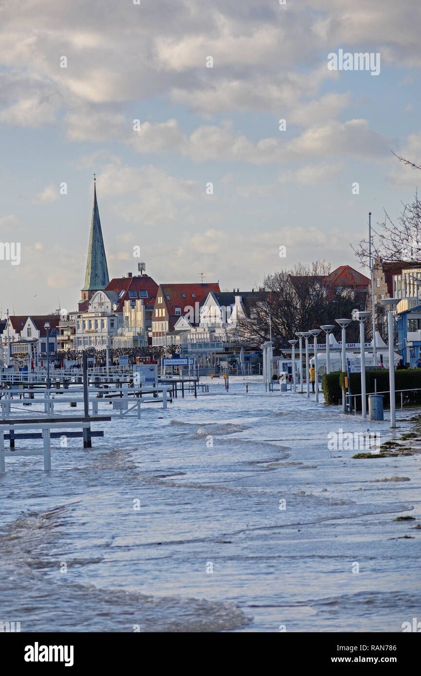 TRAVEMUENDE, Germania, 2 gennaio 2019: l'acqua alta ha invaso la passeggiata nella famosa località turistica di Travemuende presso il Mar Baltico, il cielo blu con c Foto Stock