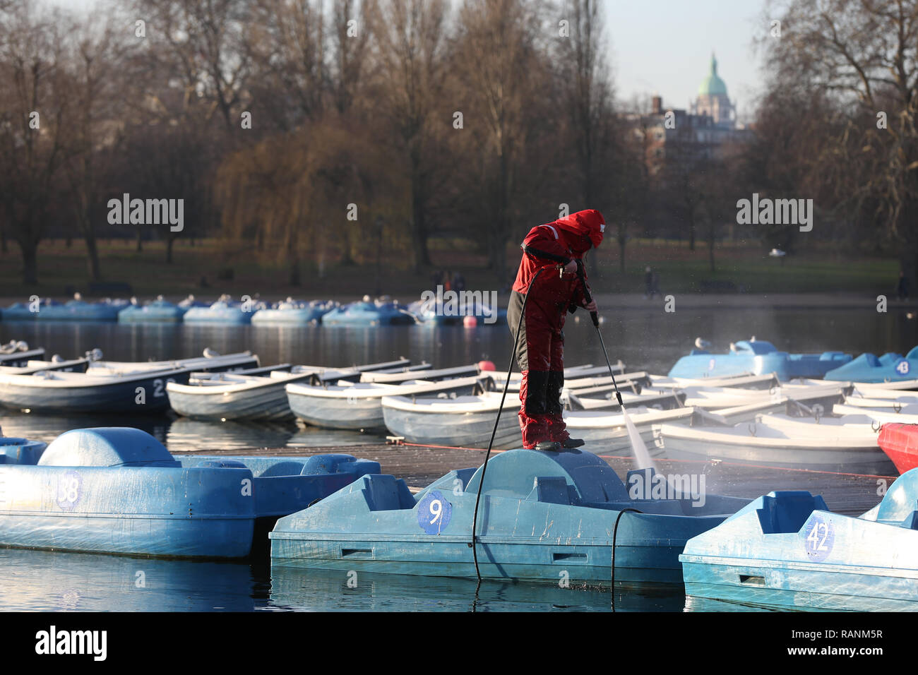 Un lavoratore pulizia pedalò sulla serpentina all'Hyde Park di Londra come temperature attraverso parti della Gran Bretagna è sceso al di sotto del congelamento per tutta la notte. Foto Stock