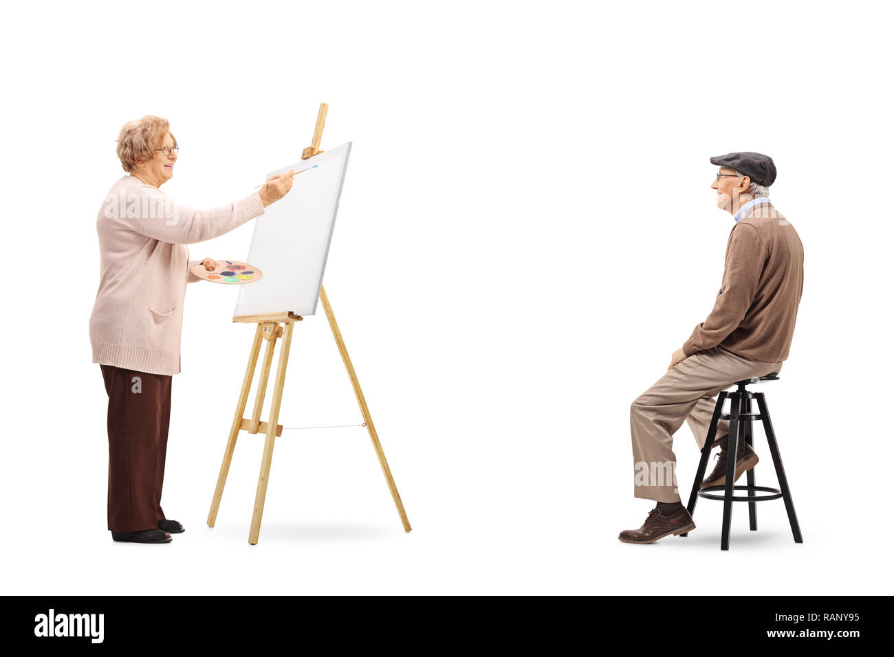 A piena lunghezza shot di una donna anziana di disegno di un ritratto di senior modello maschio su una tela isolati su sfondo bianco Foto Stock