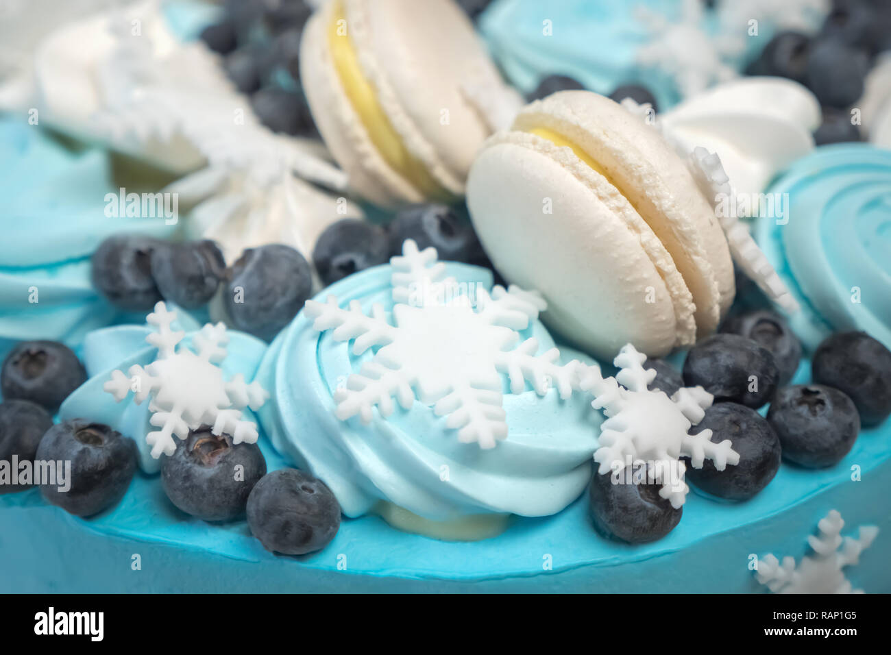 Colorato deliziosa torta con marshmallow e caramelle. Inverno tortine, biscotti. Un sano concetto di dolci. Close-up. I fiocchi di neve sulla luce blu torta. Del Foto Stock