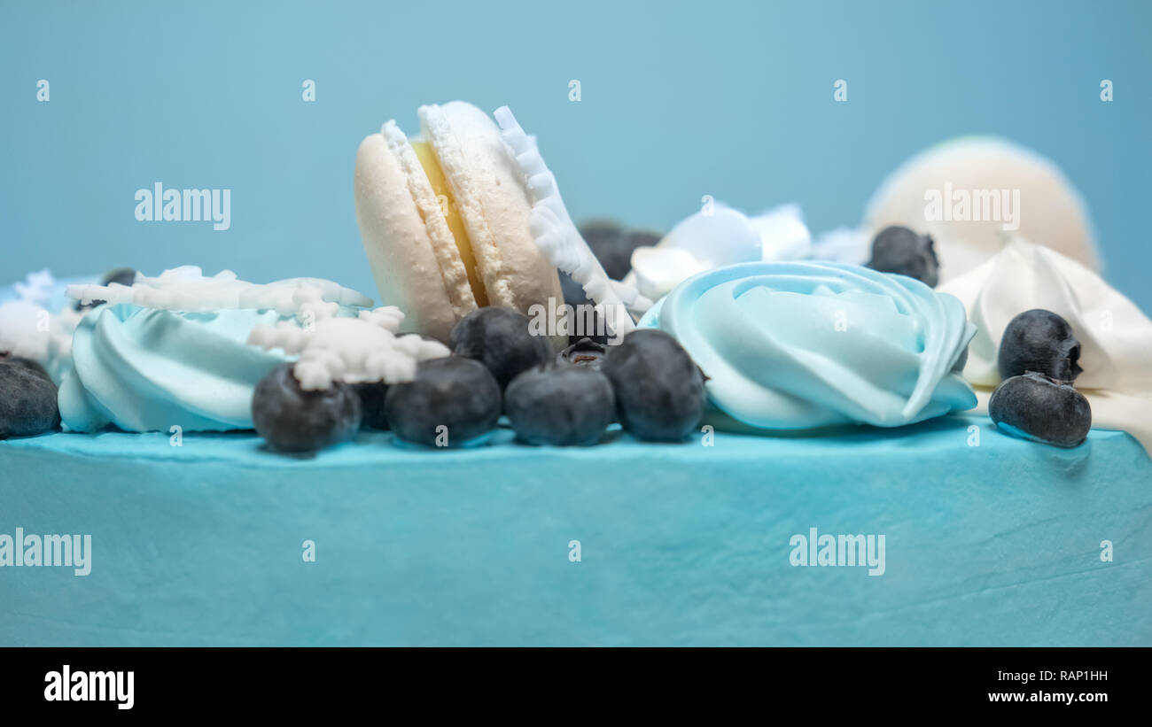 Torta ricoperta con mastice blu con marshmallows, zephir e bacche sulla parte superiore. Decorazione Torta per eventi d'inverno. Pasticceria web assaporare. Nuovo anno torta Foto Stock