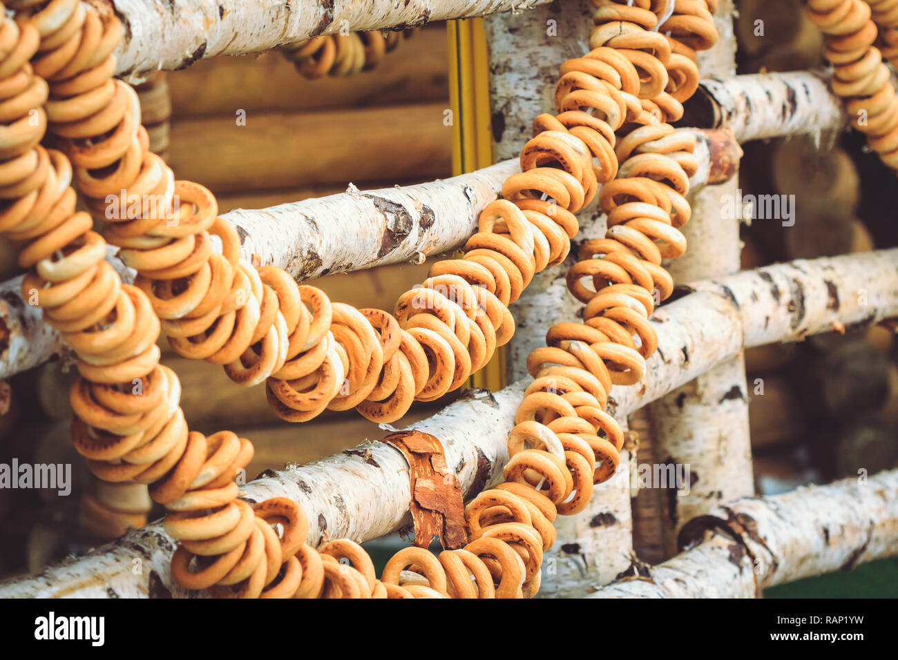 Bagel in un mazzetto appendere su una tavola di legno di betulla, recinto da un tradizionale russo trattare Foto Stock