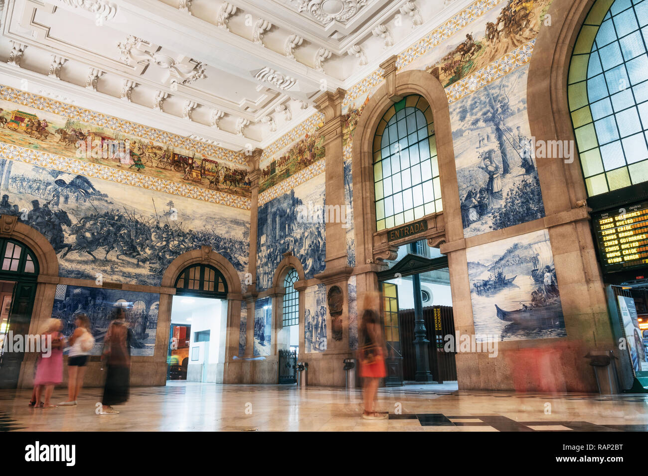 Ceramica Azulejos tileworks sulle pareti della sala principale di alla Stazione Ferroviaria di Sao Bento con blur turisti, Porto, Portogallo Foto Stock