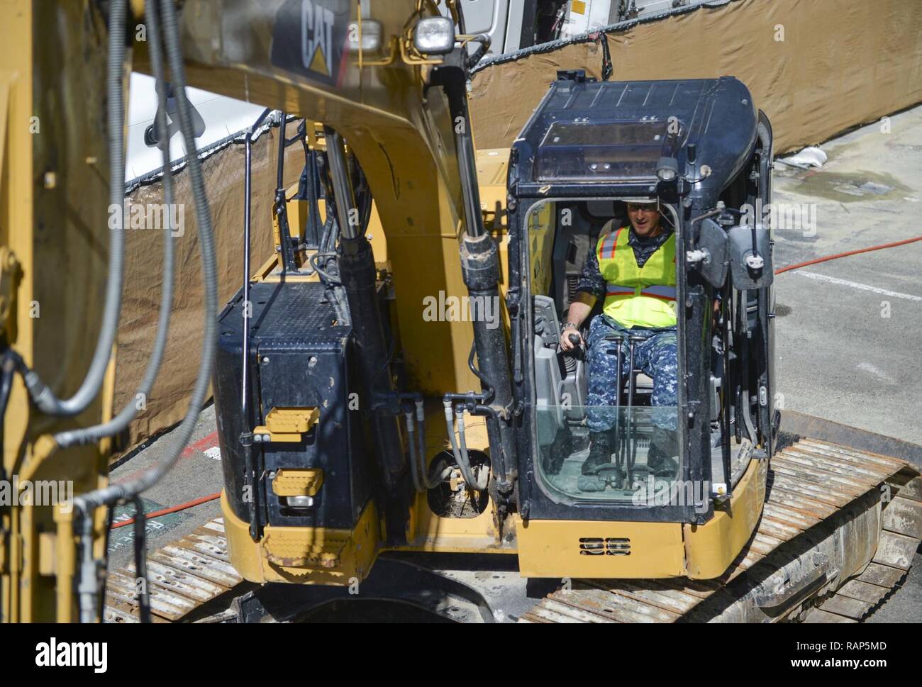 SAN DIEGO (feb. 21, 2017) Capt. Joel Roos, comandante navale Centro Medico San Diego (NMCSD) si siede in un escavatore on-site dell'edificio 11 progetto di demolizione NMCSD onboard. Roos ha visitato il palazzo al sondaggio del sito e far oscillare il primo martello nella sua distruzione. Foto Stock