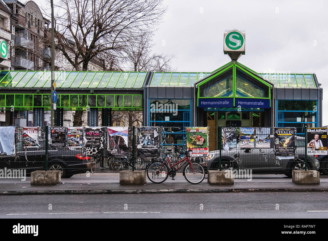 Hermannstrasse S-Bahn stazione ferroviaria esterno e dal soffitto in vetro con il blu del cielo e alberi vernice - Neukölln, Berlino Foto Stock