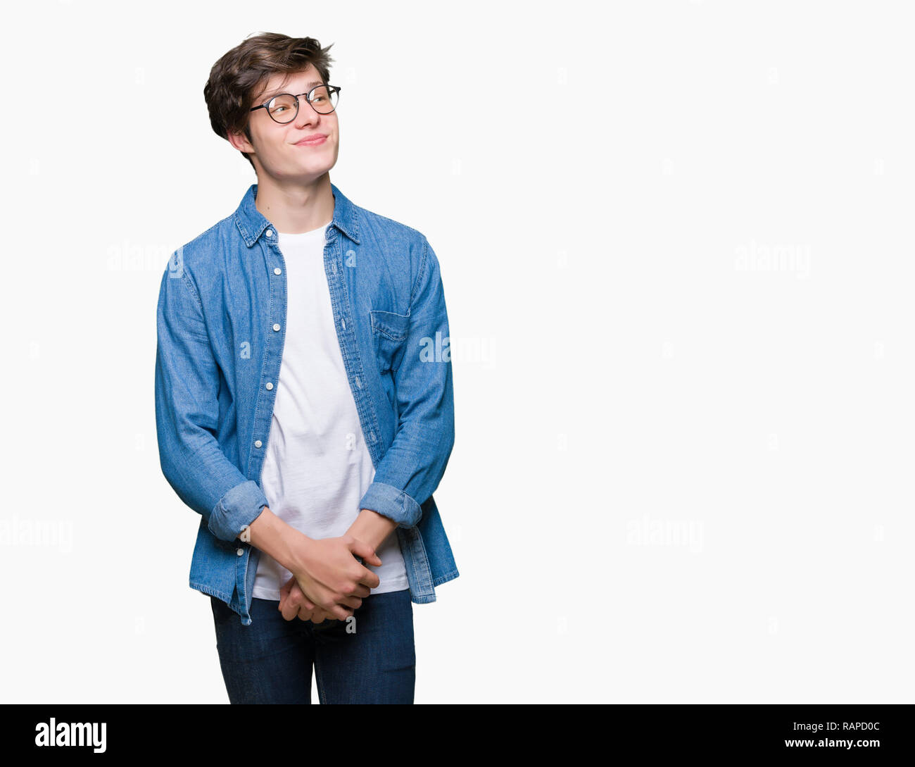 Giovane uomo bello con gli occhiali su sfondo isolato sorridente cercando lato e lo sguardo lontano pensando. Foto Stock