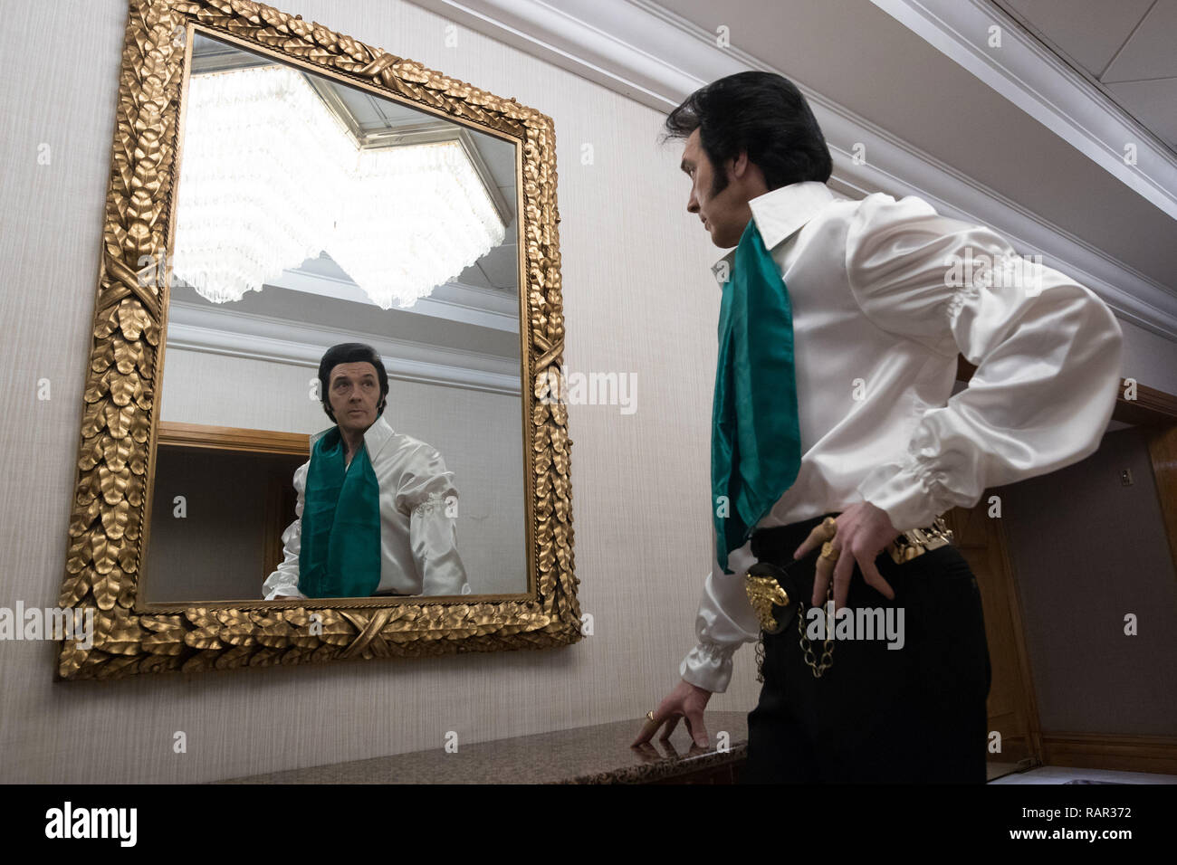 Jeff Hermau un Elvis atto guarda nello specchio al più grande d'Europa annuale di Elvis artista Convenzione contenuto all'Hilton Birmingham Metropole Hotel. Foto Stock