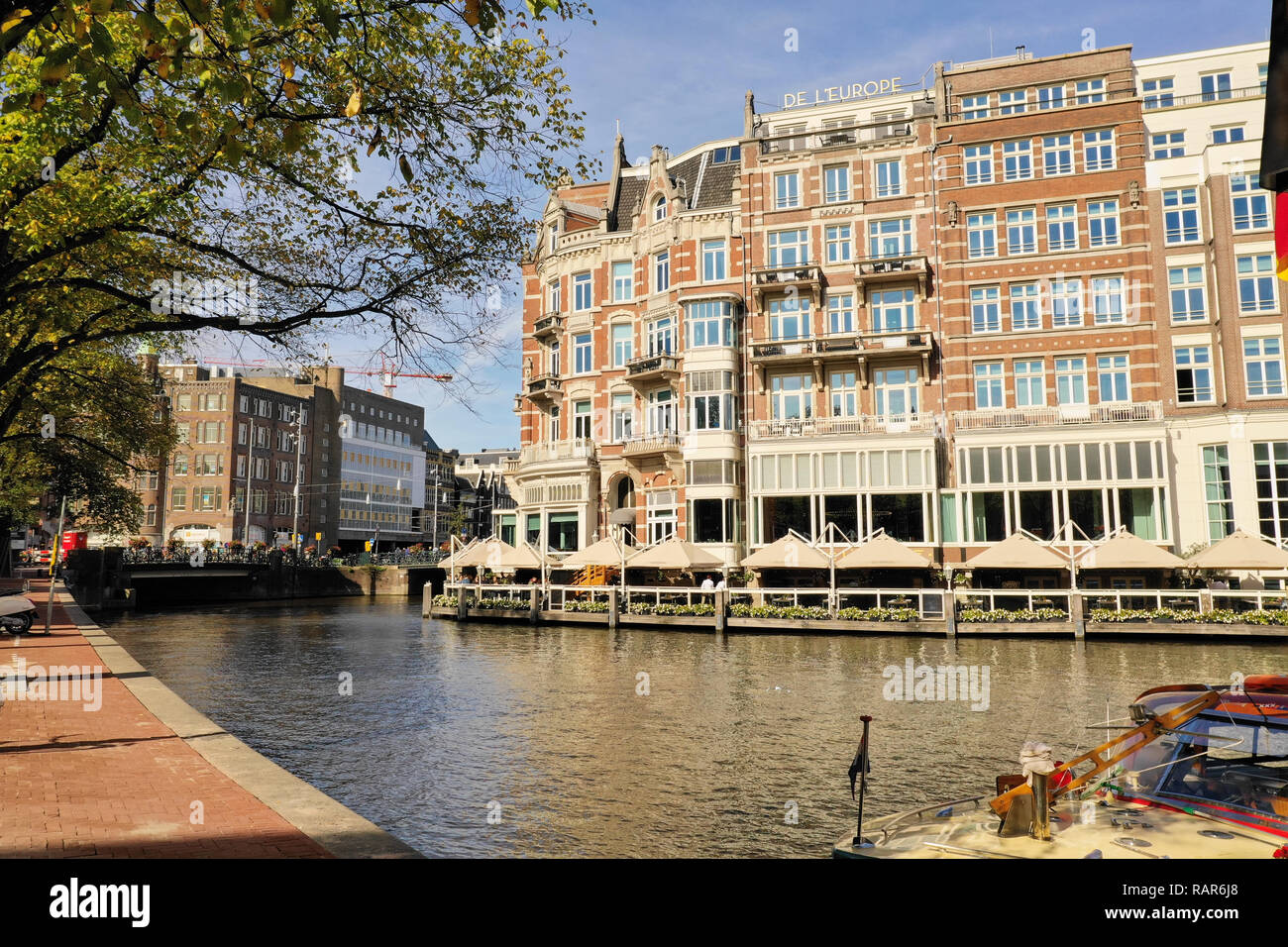Uno dei la più bella di edifici di Amsterdam: De L'Europe Amsterdam Hotel, con barche passando sulla Amstel Foto Stock