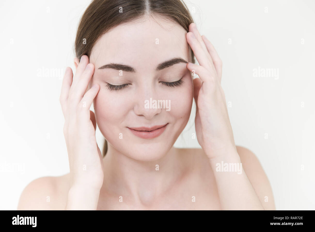 Le donne con Beauty face self massaggio testa rub sorriso relax il dolore per alleviare lo stress. Foto Stock