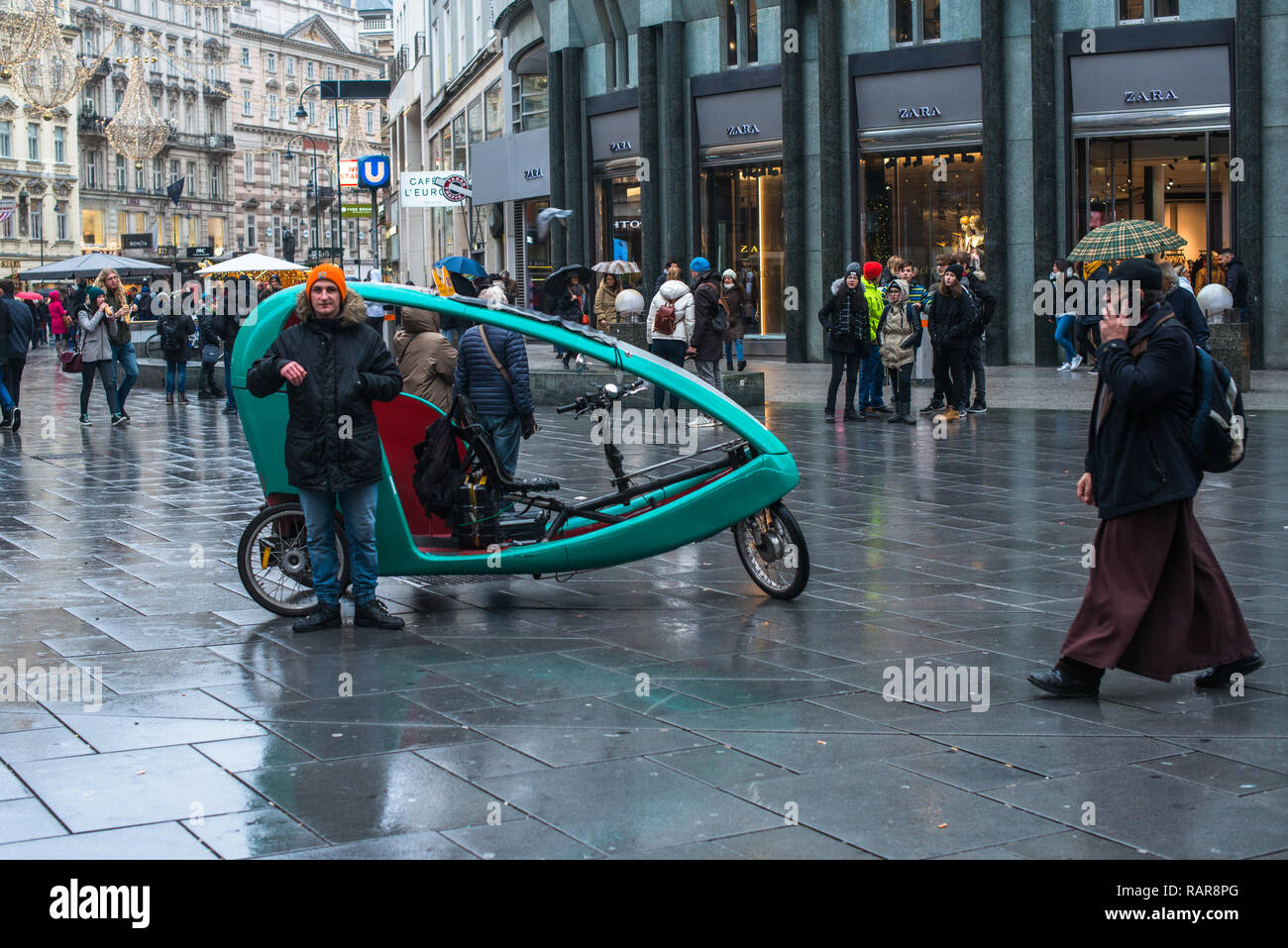 Una bicicletta con taxi sulla Stephansplatz St Stephens quadrato in un giorno di pioggia, Vienna Austria Europa. Foto Stock