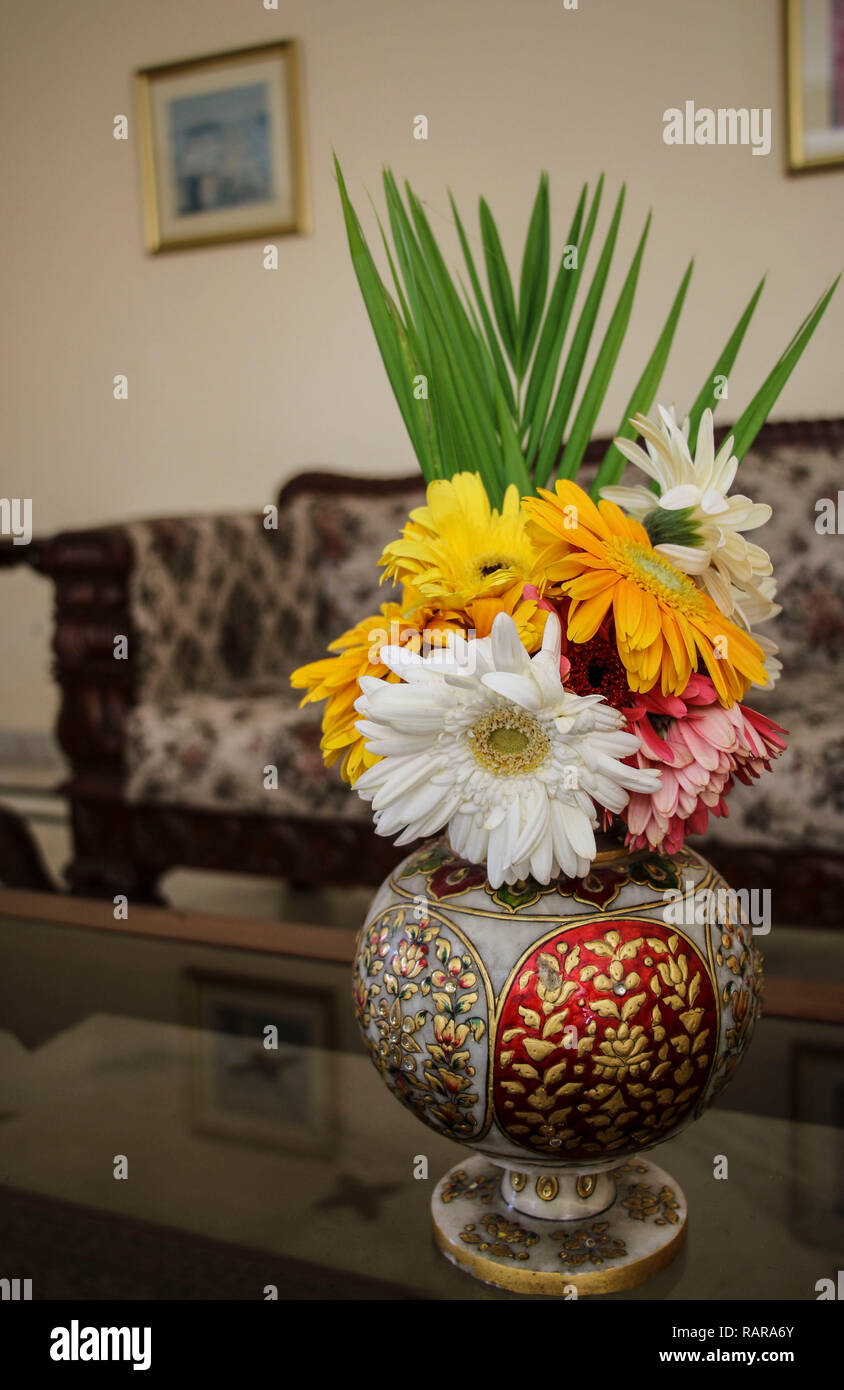 Gerbera colori diversi in un vecchio stile indiano vaso in interni Foto Stock