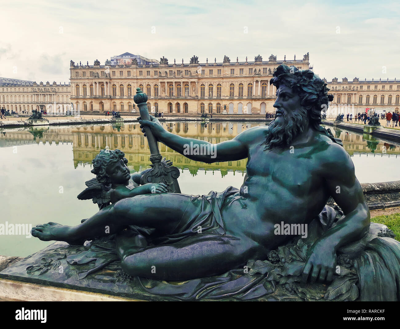 Scultura in bronzo nel giardino del palazzo di Versailles vicino a Parigi, in Francia con il riflesso nella fontana di acqua. Foto Stock
