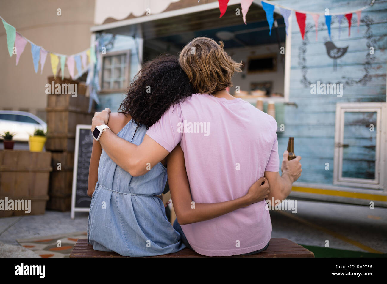 Vista posteriore della coppia romantica seduto con bottiglia di birra Foto Stock