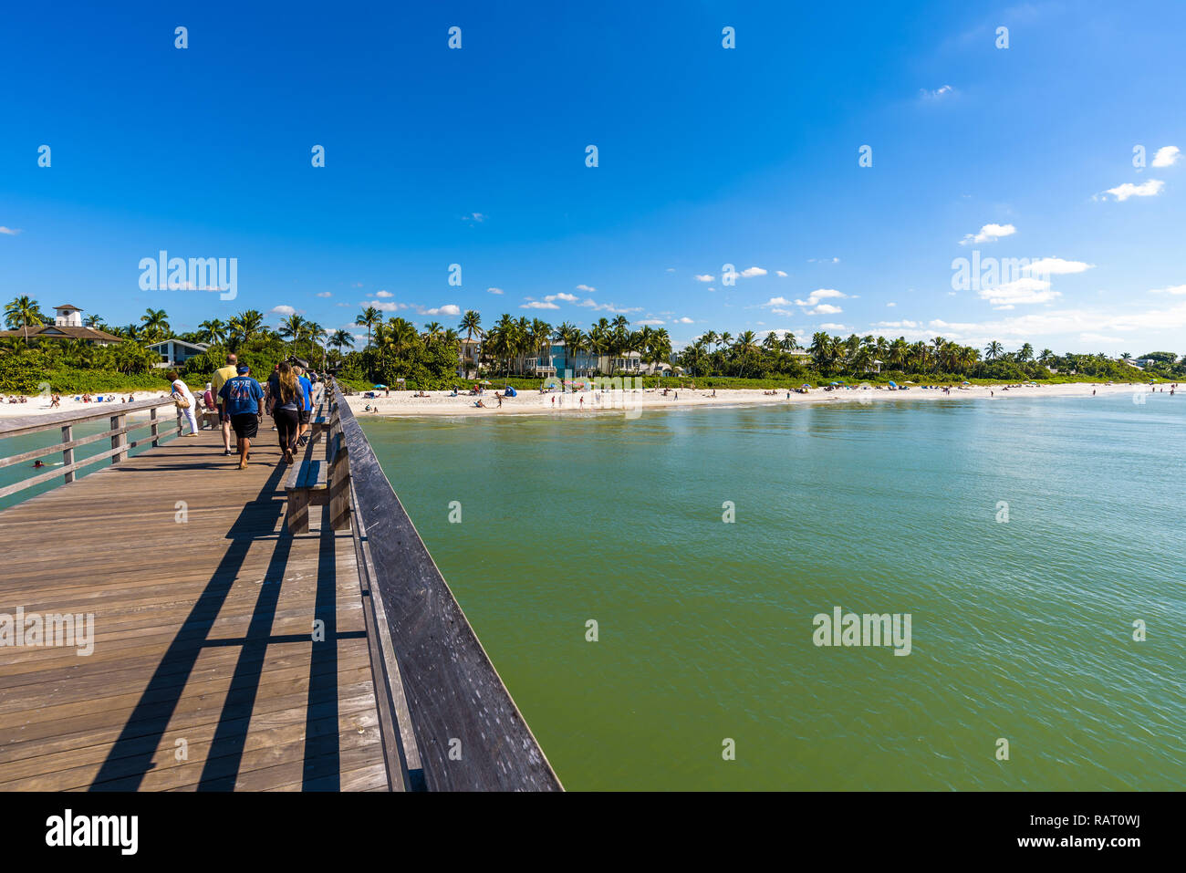 Vista dei turisti su Napoli Beach, Florida, con la sua sabbia bianca e il mare turchese in una giornata di sole come si vede dal famoso molo, popolare luogo di pesca. Foto Stock