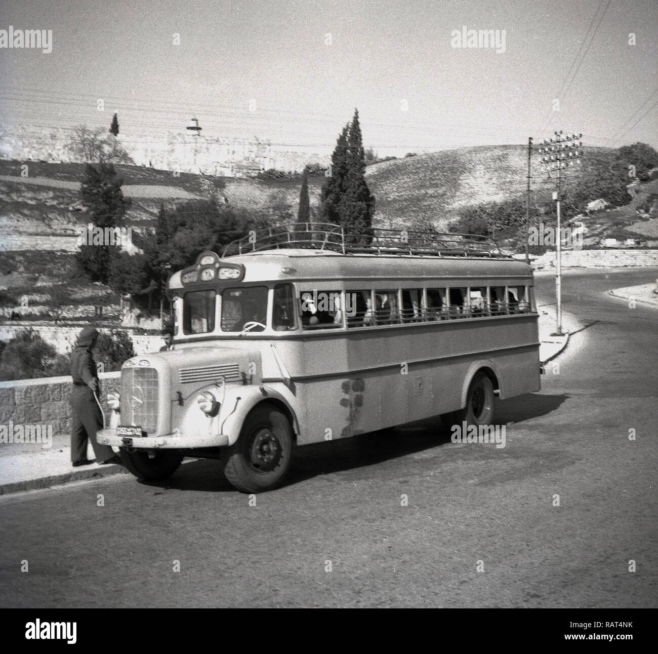 1940s, storico, Palestina, al di fuori di Gerusalemme, un soldato parlando con un autista di autobus sul marciapiede, con la mercedes-benz autobus parcheggiato accanto a loro. Foto Stock