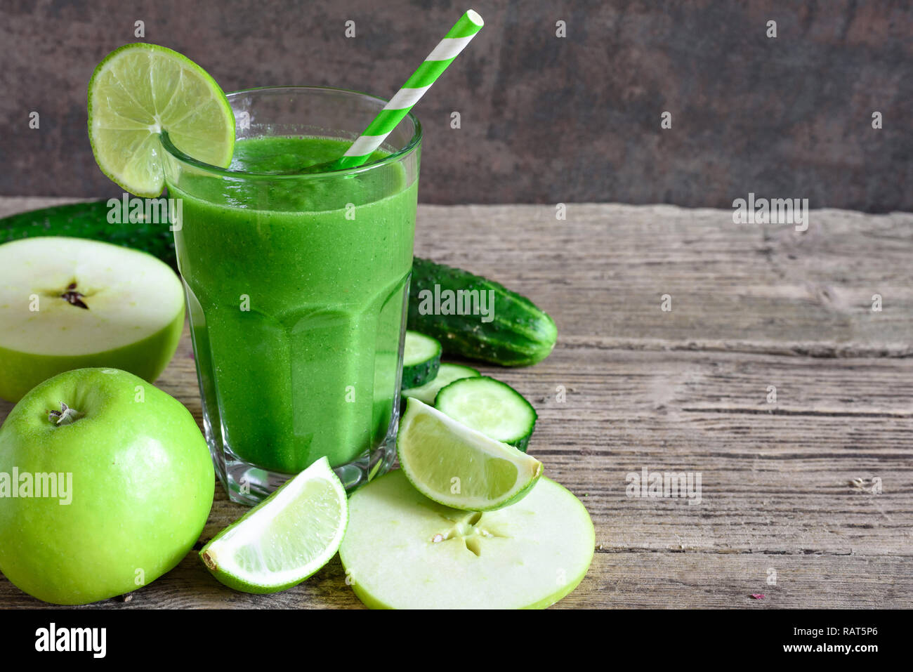 Frullato di verde in un bicchiere con spinaci, Apple, cetriolo e calce con una cannuccia. detox drink. close up Foto Stock