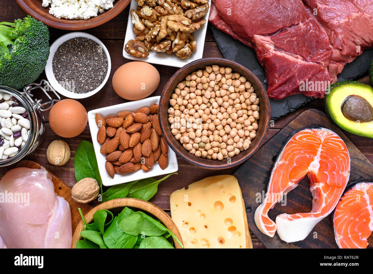 Alimenti ad alto contenuto proteico - piatti a base di pesce e carne, pollame, dadi, uova e verdure. Il mangiare sano e la dieta concetto. vista superiore Foto Stock