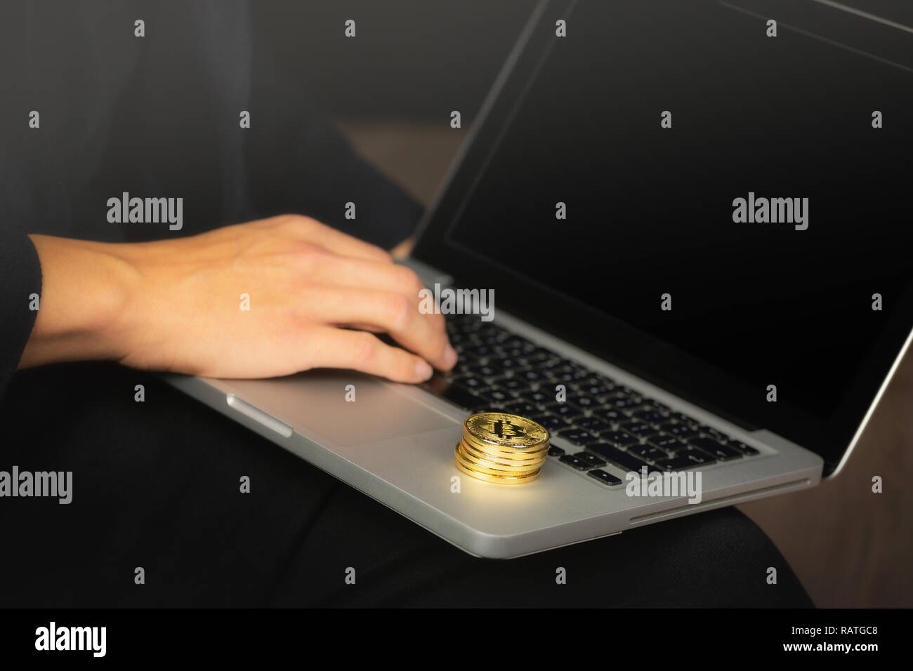 Imprenditore lavorando sul computer portatile con un golden bitcoin monete pila su di esso. Foto Stock