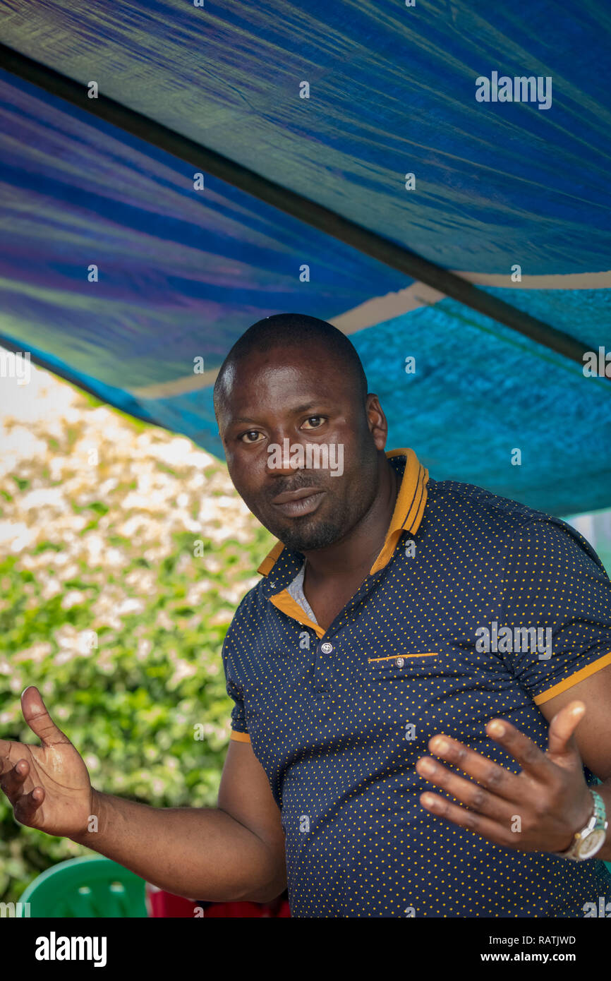 Uomo ugandese gesticulating con le mani Foto Stock