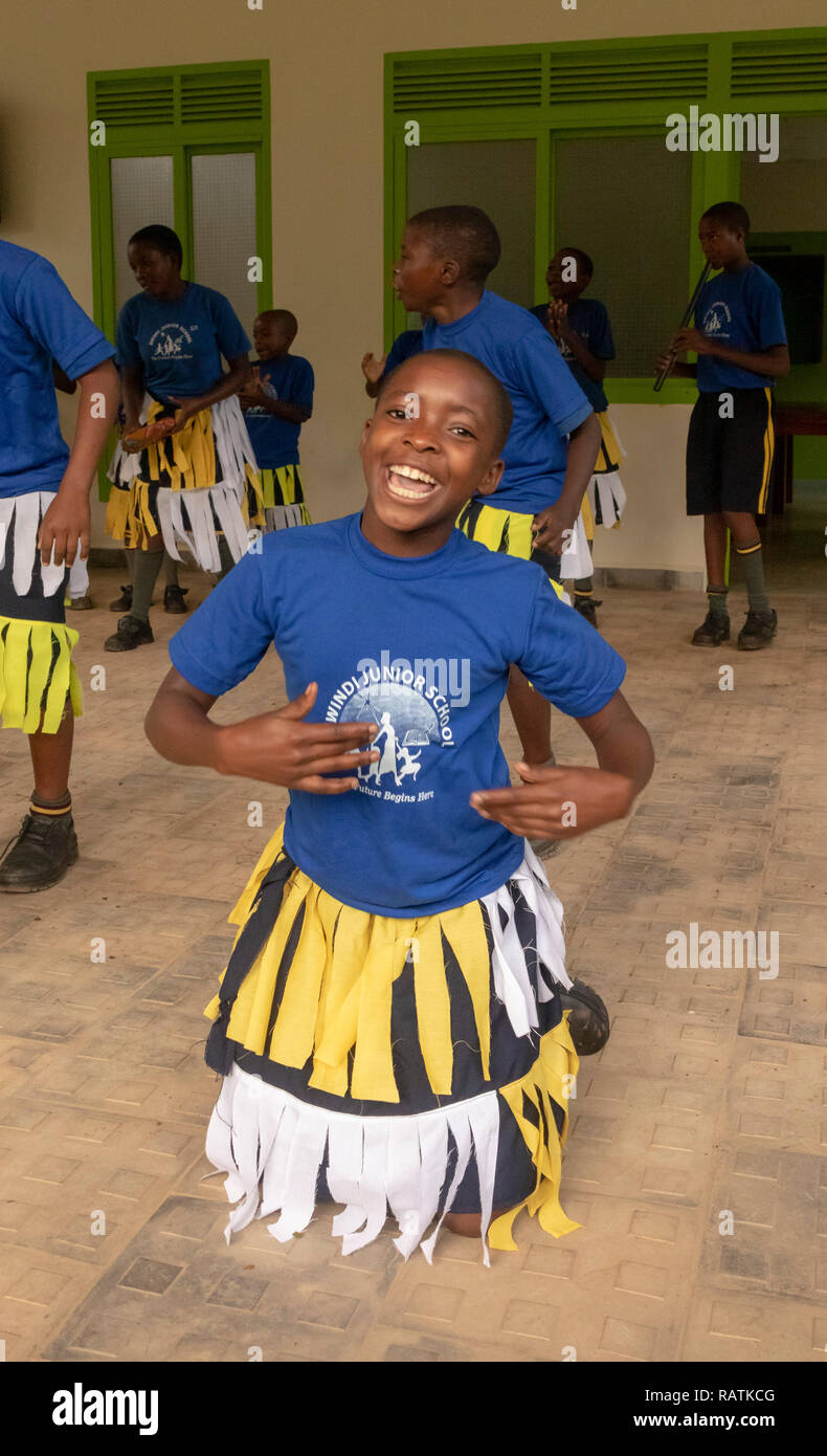 Scolari da Bwindi scuola junior di eseguire una danza per i turisti prima di gorilla trekking safari, parco nazionale impenetrabile di Bwindi, Uganda Foto Stock