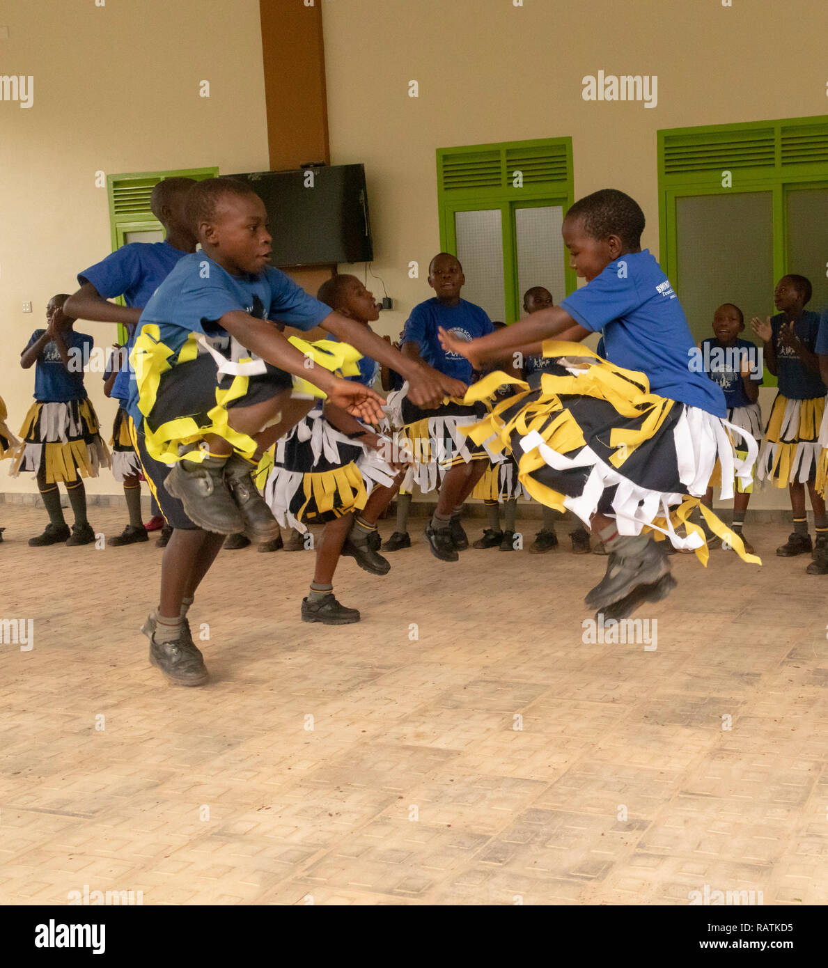 Scolari da Bwindi scuola junior di eseguire una danza per i turisti prima di gorilla trekking safari, parco nazionale impenetrabile di Bwindi, Uganda Foto Stock