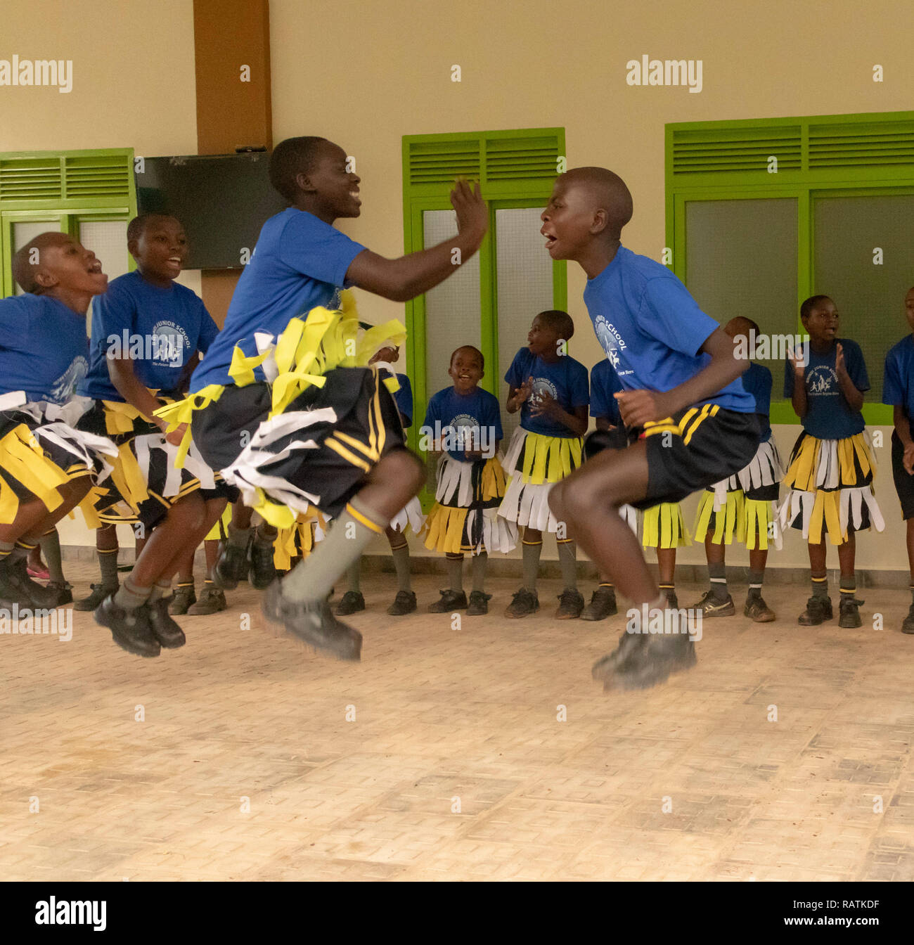 Scolari da Bwindi scuola junior di eseguire una danza per i turisti prima di gorilla trekking safari, parco nazionale impenetrabile di Bwindi, Uganda Foto Stock