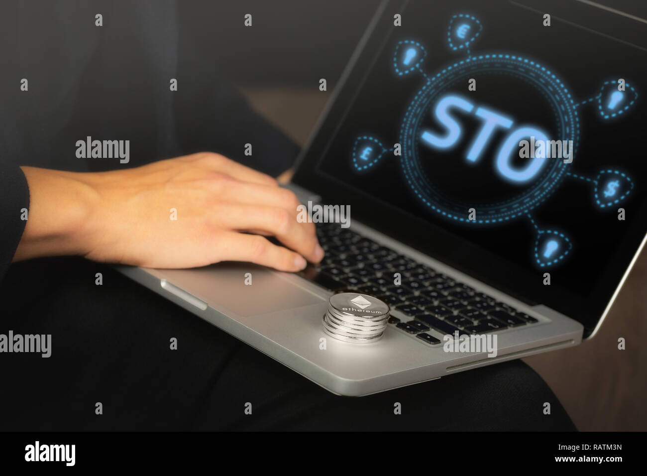 Token di protezione offerta (STO) testo scritto su uno schermo portatile tenuto da un uomo d affari con una pila di Ethereum Foto Stock