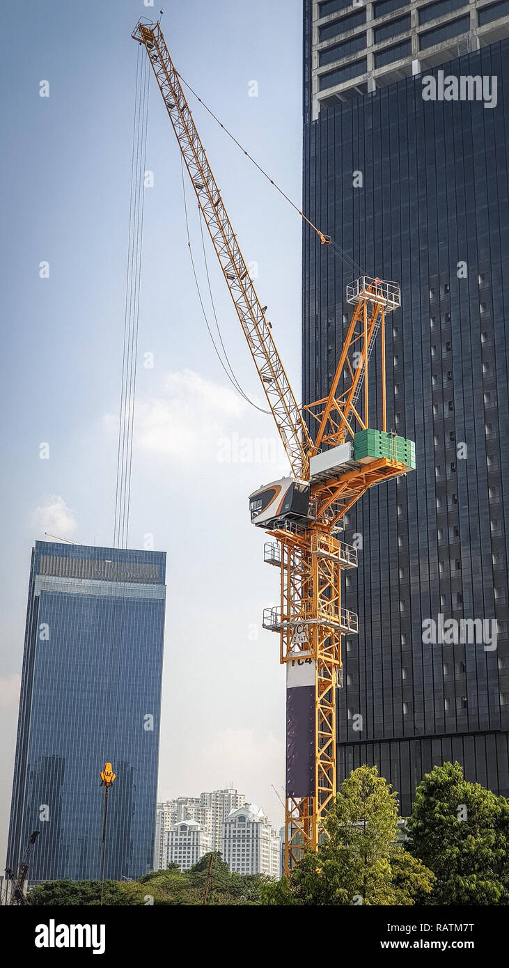 Foto costruzione di gru occupato a lavorare al mattino Foto Stock