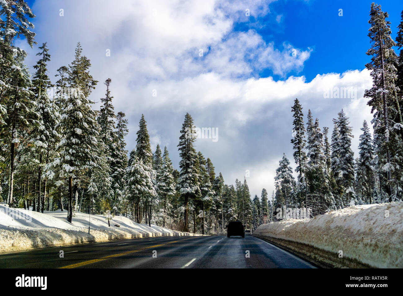 Viaggiando su una strada tortuosa attraverso la Sierra Mountains su una giornata invernale Foto Stock