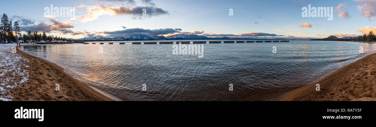 Tramonto sulla spiaggia di South Lake Tahoe, Sierra cime coperte di neve visibile in background, California Foto Stock