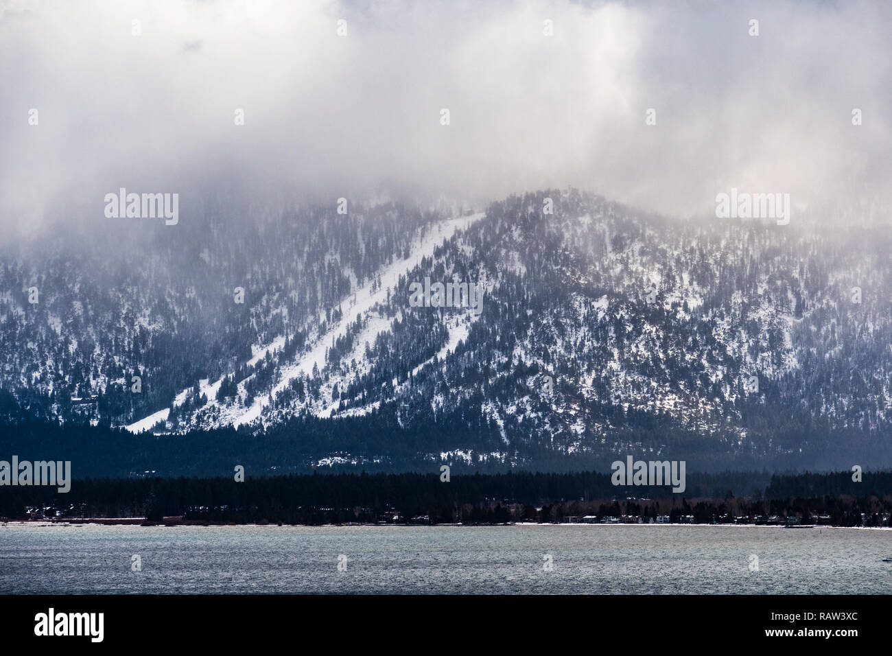 Nuvole temporalesche che copre la Sierra Mountains, il litorale del Lago di Tahoe visibile in primo piano Foto Stock