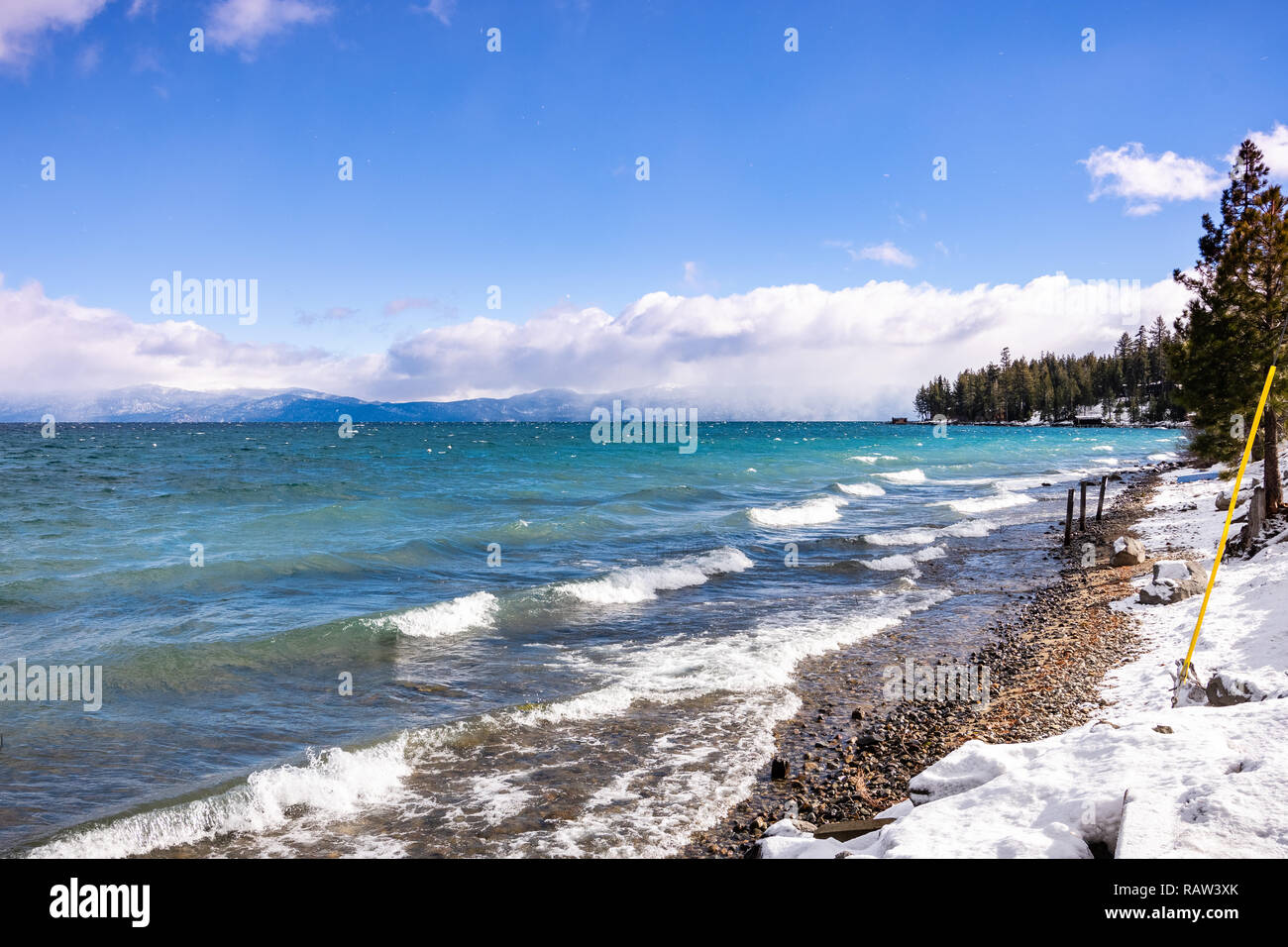 Soleggiata giornata invernale sul litorale del Lago di Tahoe, Sierra Nevada, in California; rottura surf creato dal vento si infrangono sulla riva; Foto Stock